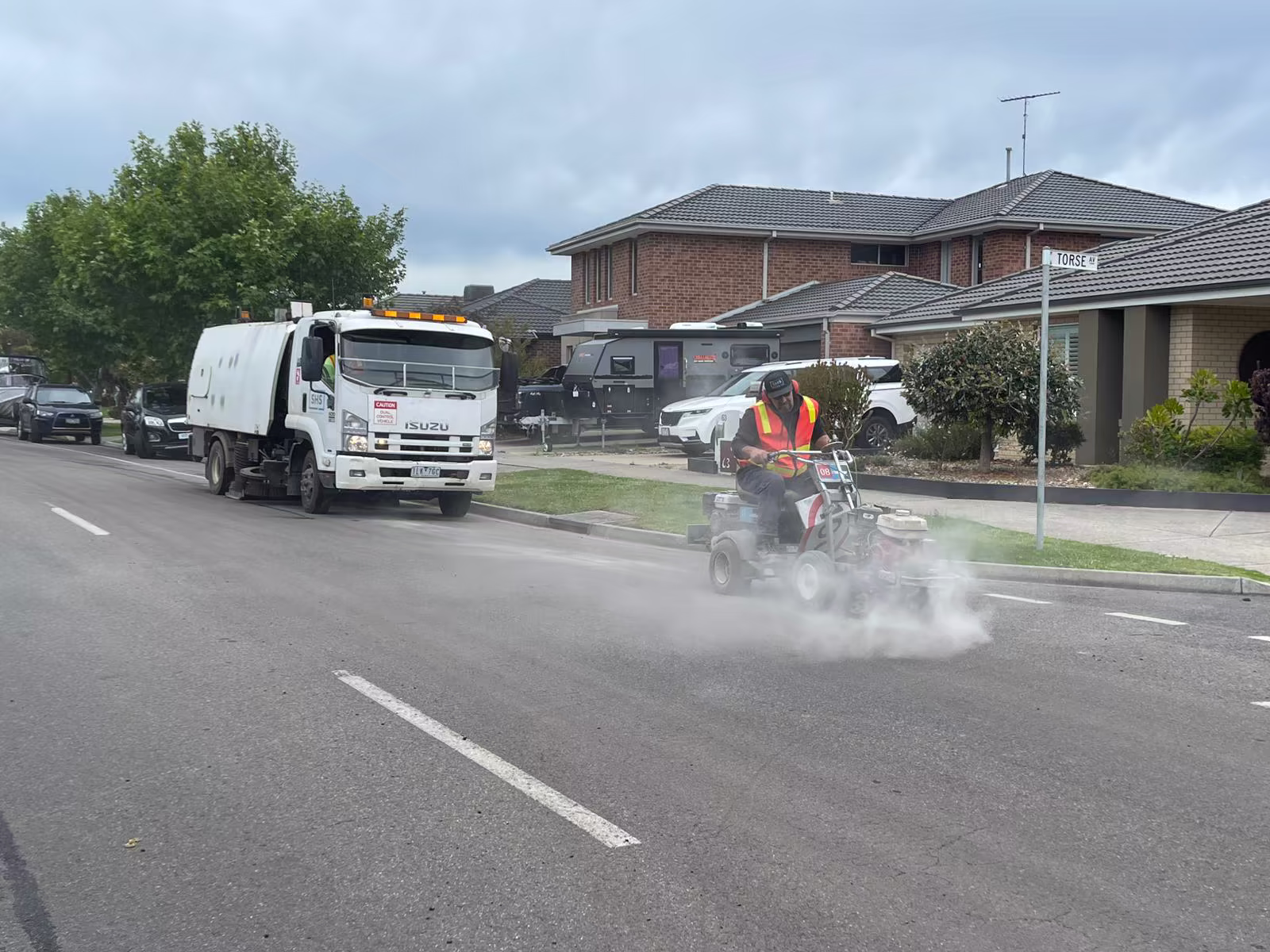 Ride-on grinder removing line marking on a residential street