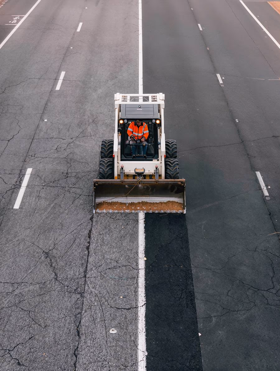 Ride-on grinding machine removing a road line
