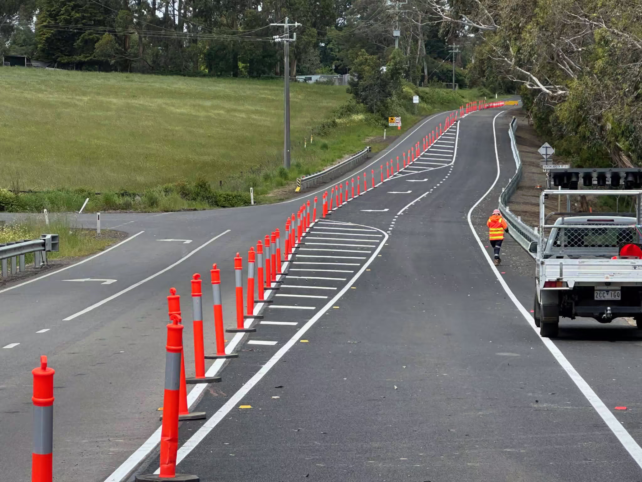 Fresh line marking on a rural road with traffic bollards and a Southern Highway crew vehicle